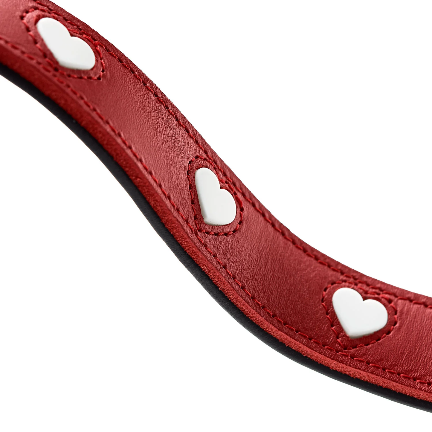 Gros plan sur les motifs cœur blancs de la laisse Love en cuir rouge