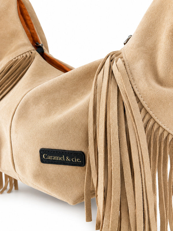 Détail de la matière effet suédine et des franges du sac pour chien blanc cassé
