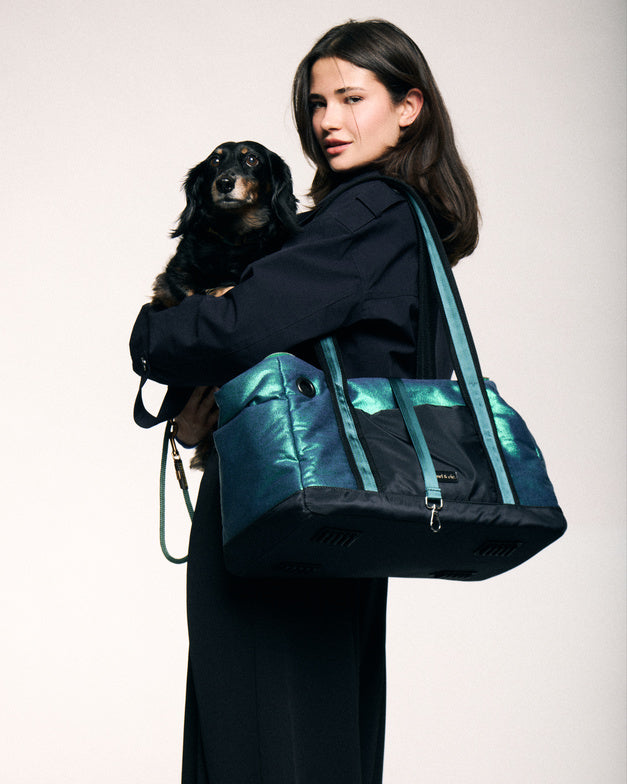 : Pet City Bag vert métallisé porté à l’épaule avec un petit chien